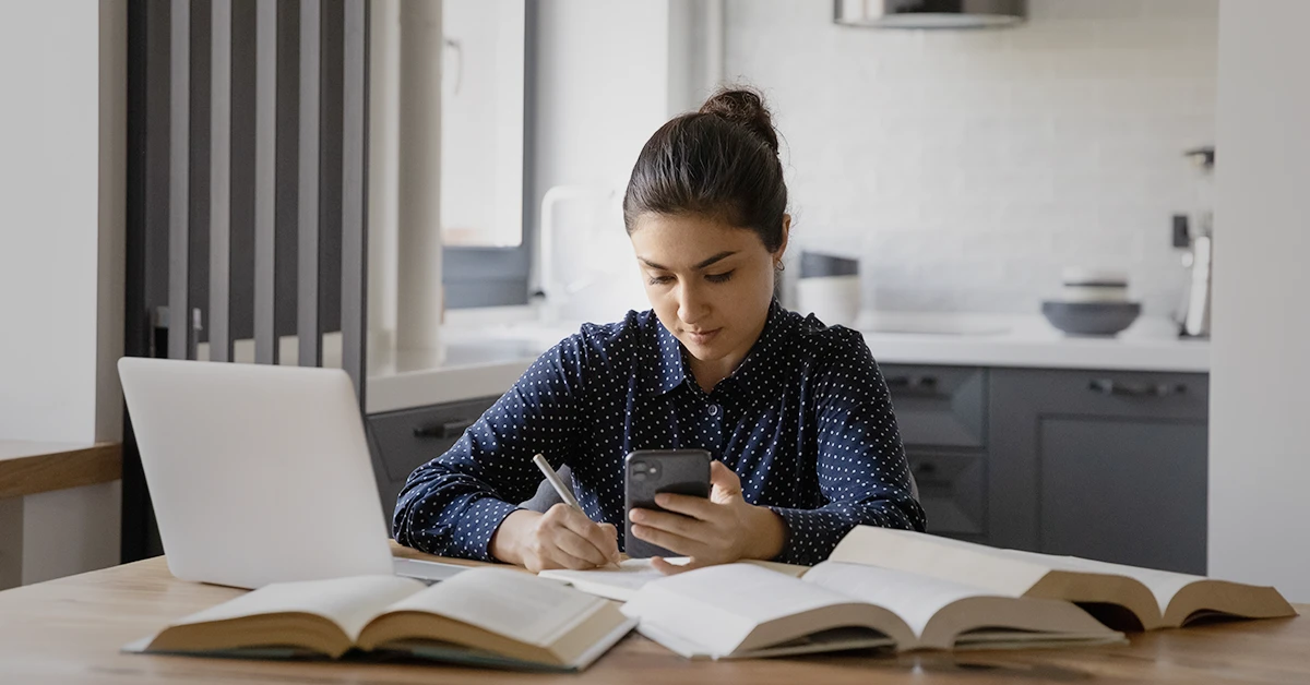 Student studying with books and laptop for exam preparation